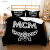 Black duvet cover featuring the MCM logo design on a bed.