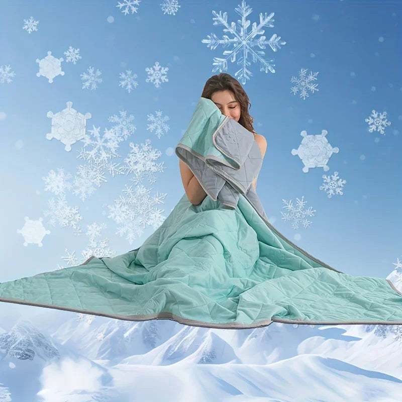 A woman is wrapping herself in a light green cooling blanket against a snowy, blue background with falling snowflakes.