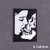 Black embroidery patch featuring a stylized profile of a human face and skull.
