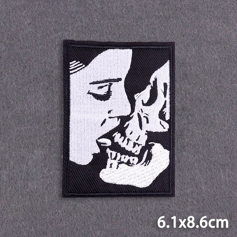Black embroidery patch featuring a stylized profile of a human face and skull.
