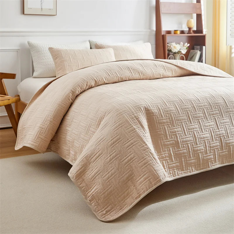 A beige quilted cotton bedspread set featuring a textured pattern on a bed with white pillows.