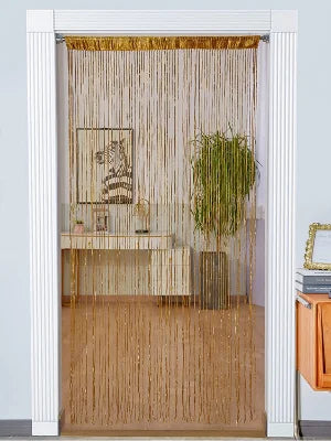 Decorative door string curtains in gold thread hanging in a white framed doorway.