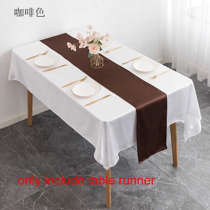 A dark brown satin table runner is displayed on a white tablecloth set for a formal dining arrangement.