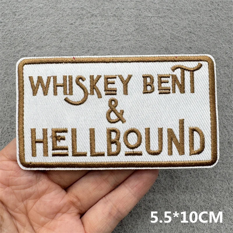 A rectangular beige embroidered patch with brown text reading Whiskey Bent & Hellbound