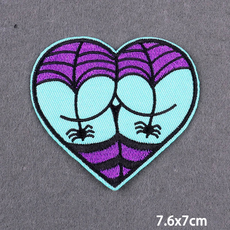 A heart-shaped embroidery patch featuring purple and light blue stripes with stylized bird or insect designs.