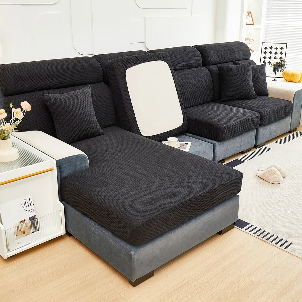 A dark gray Jacquard Elastic Sofa slipcover with light gray upholstery and white accents on a wooden floor.