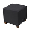 A dark gray woven fabric ottoman slipcover with wooden legs.