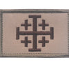 A rectangular embroidered patch featuring a dark brown cross design on a light beige fabric background.