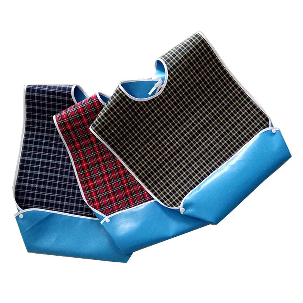 Adult waterproof mealtime bib with adjustable neck and catch-all pocket featuring plaid fabric and blue leather trim