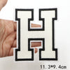A hand holds a black letter H patch with a cream background, measuring 4cm.
