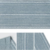 A close-up view of a blue embroidered cotton linen table runner with white tassels.