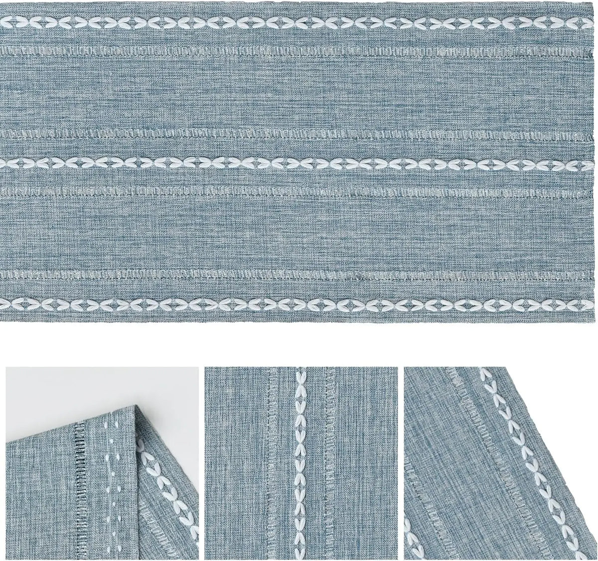 A close-up view of a blue embroidered cotton linen table runner with white tassels.