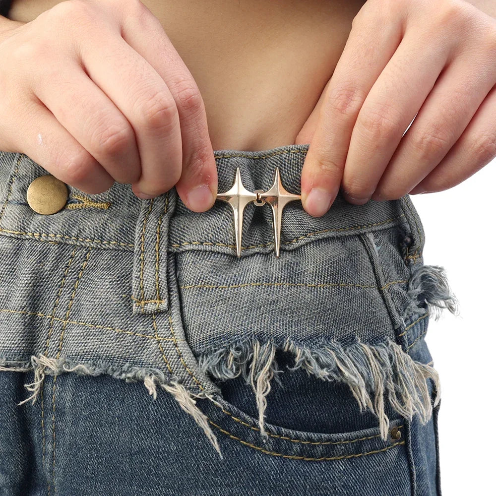 Close-up of hands fastening adjustable star-shaped buttons onto denim jeans
