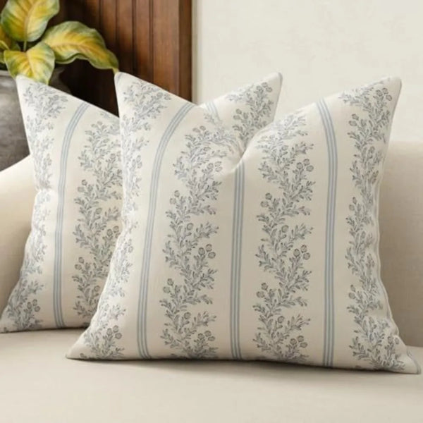 A close-up of a vintage striped floral throw pillow cover with gray and white botanical patterns.