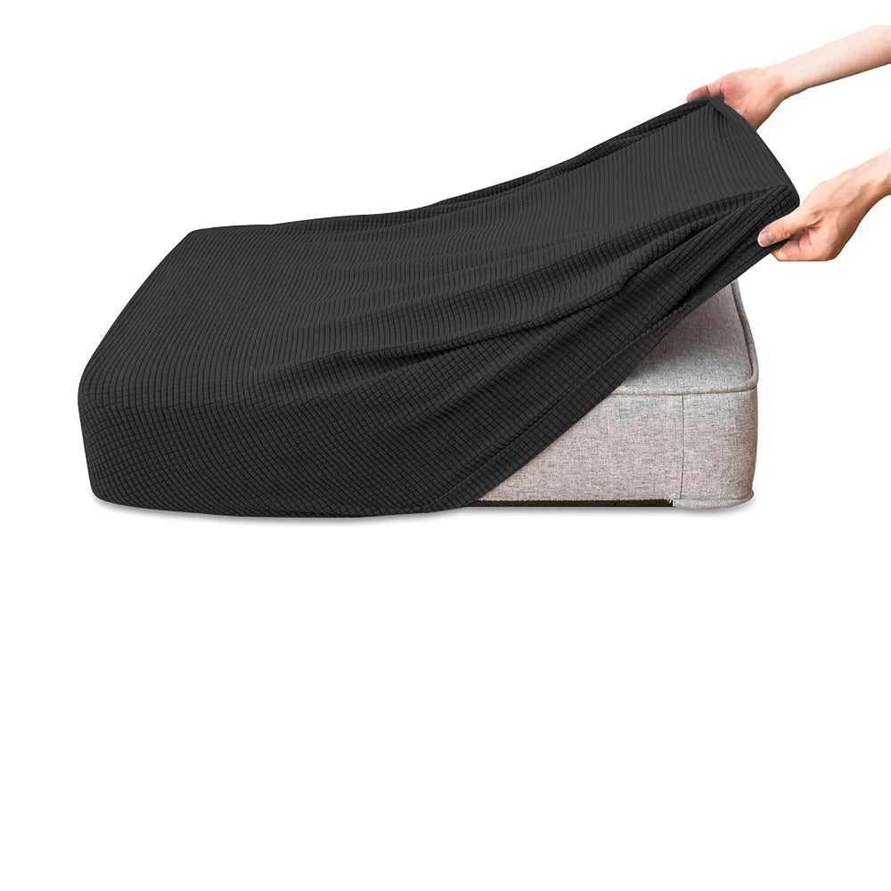 A black polar fleece jacquard sofa seat cushion cover being held by a hand.