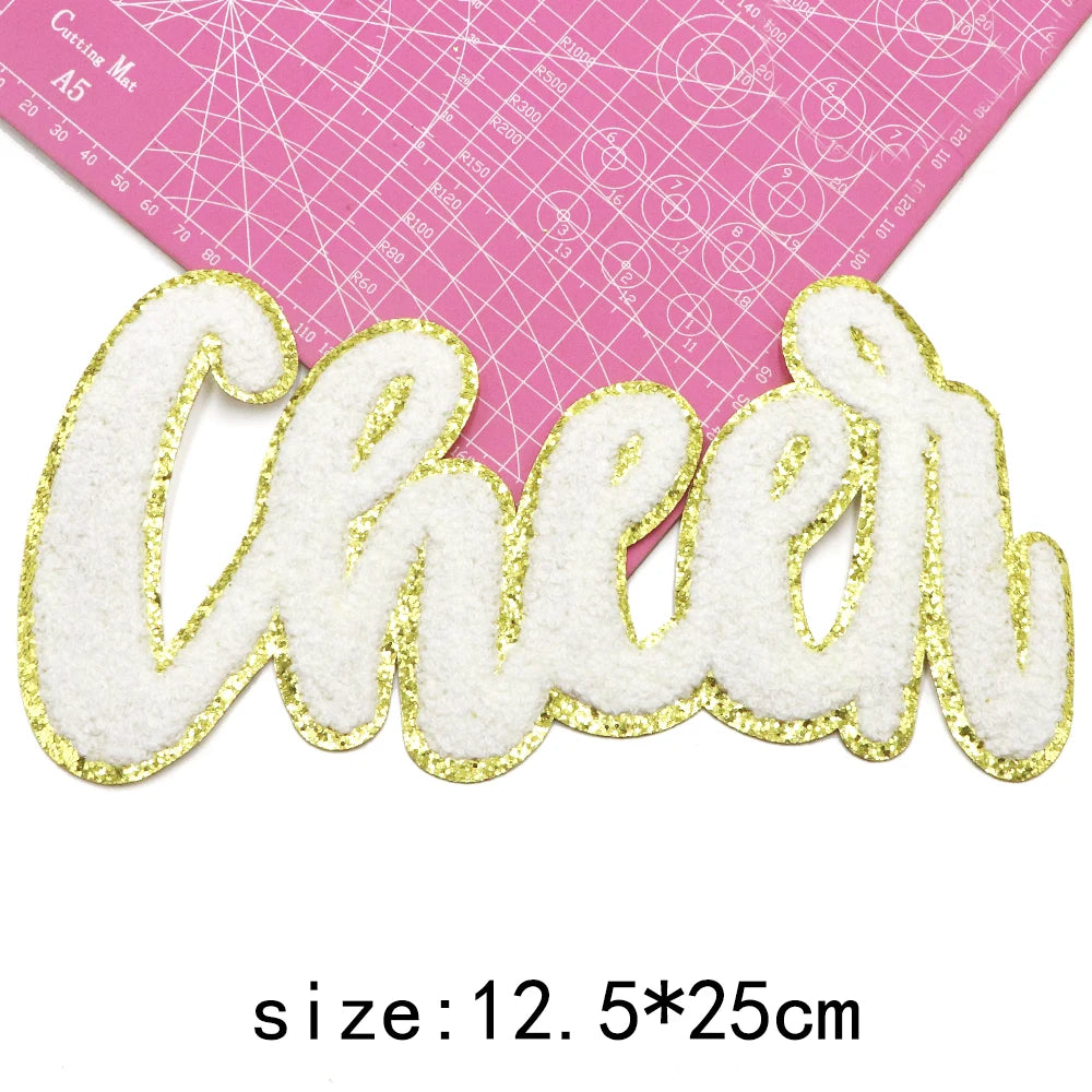 Gold glitter embroidered letter cheer patch on pink cutting mat