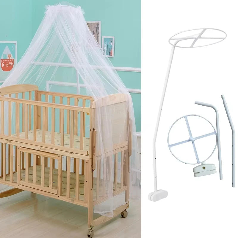 A wooden infant cot with a sheer white mosquito net canopy draped over it.