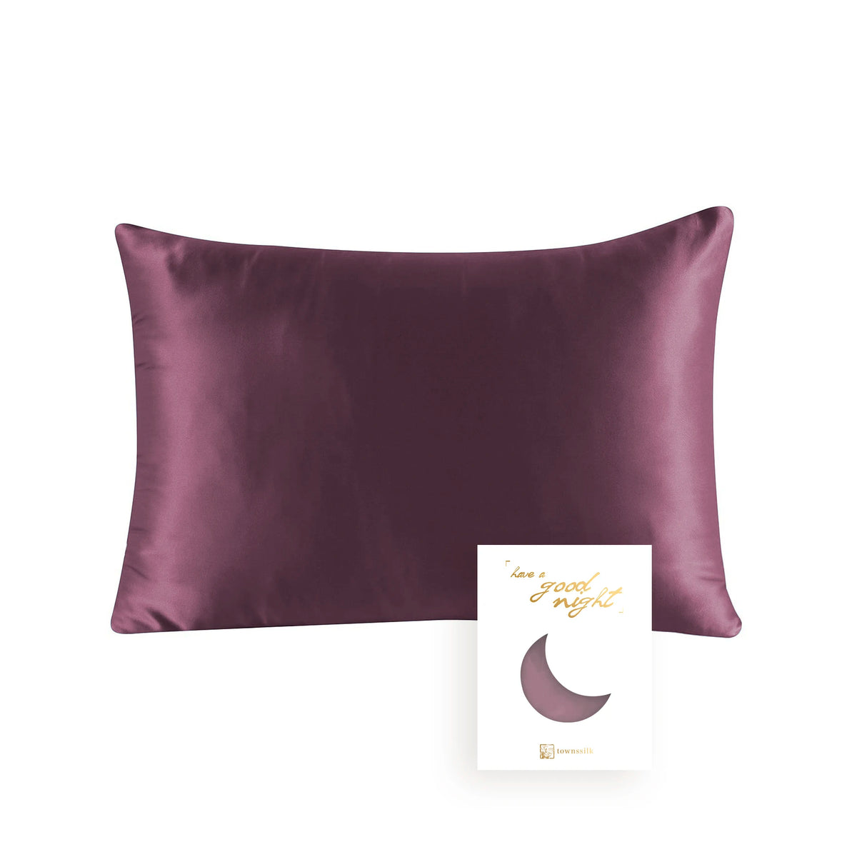 A deep plum colored silk pillowcase with a hidden zipper and a crescent moon design on the tag.