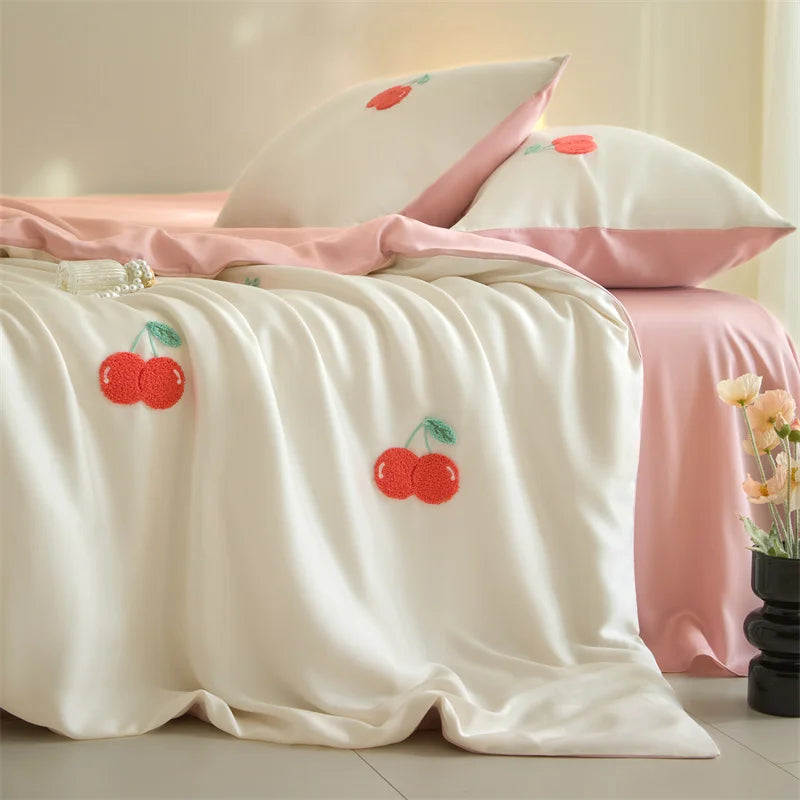 White duvet cover set with pink accents and embroidered red cherries on a bed
