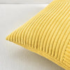A close-up of a yellow retro corduroy patchwork pillow cover with vertical ribbed texture.