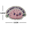 A round embroidery patch featuring a pink, fluffy, stylized brain with small eyes and green accents.