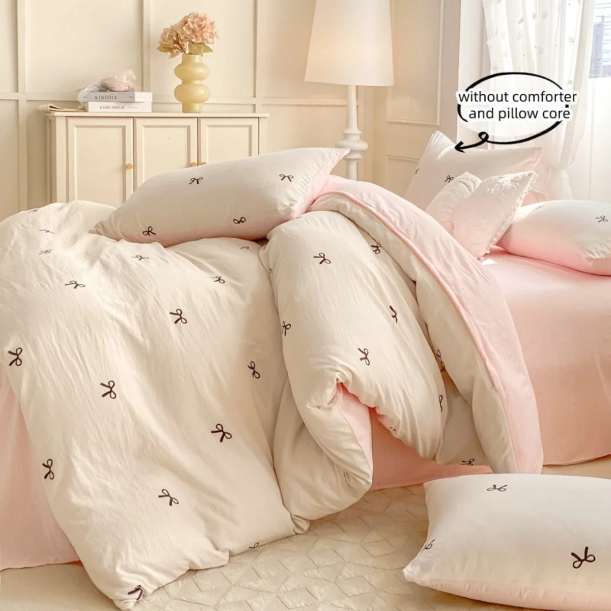 A pink bowknot embroidery duvet cover set featuring three pillows and a matching duvet on a bed.