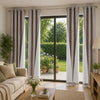Set of four linen textured blackout curtains in gray and white hanging in a modern living room