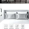 A set of silky, shiny satin pillows displayed on a white bed with icons indicating breathable, skin-friendly, and machine was