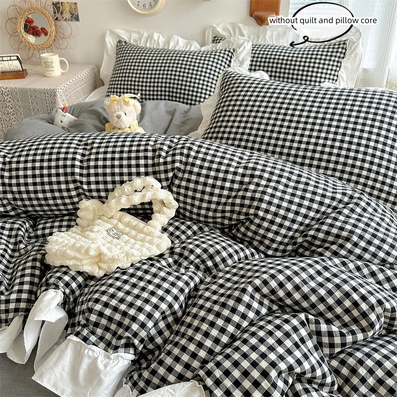A black and white plaid duvet cover set featuring lace embroidery and a fluffy white pillow.