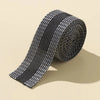 Roll of black and white self-adhesive hem tape for fabric repair