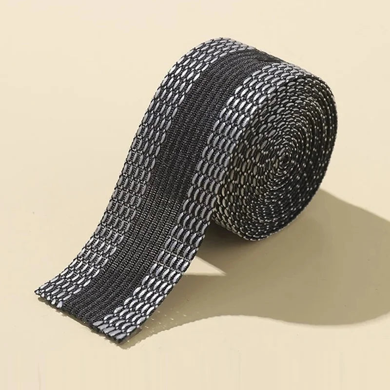 Roll of black and white self-adhesive hem tape for fabric repair