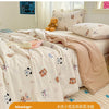 A light pink quilted blanket with a floral pattern is displayed on a bed, featuring cute animal designs.