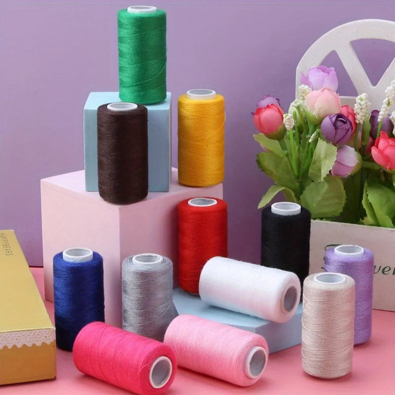 A collection of various colored polyester sewing thread spools in green, yellow, brown, red, black, and pink on a light backg