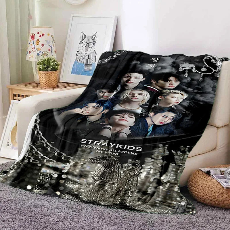 A black and white photo print blanket featuring Stray Kids members and Korean text.