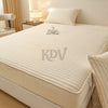 A beige fitted bed sheet set with a ribbed texture is displayed on a bed, next to a bedside lamp.
