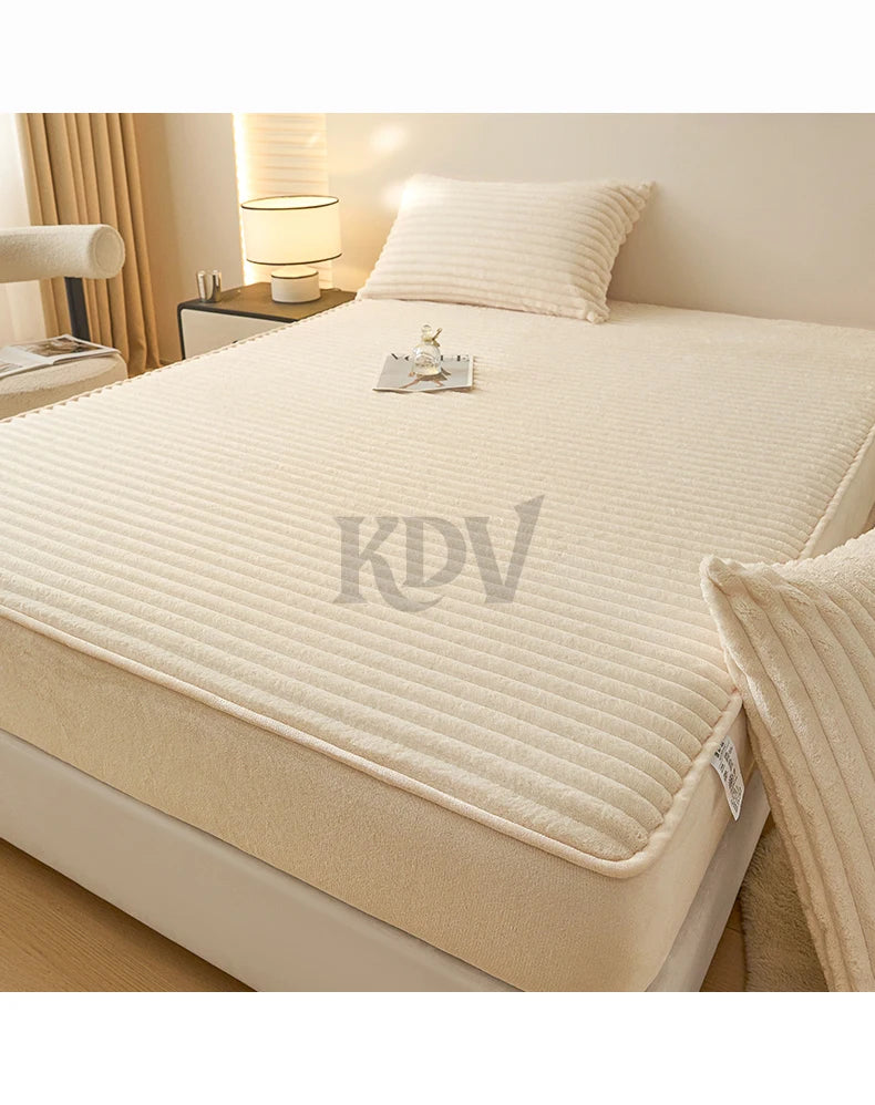 A beige fitted bed sheet set with a ribbed texture is displayed on a bed, next to a bedside lamp.