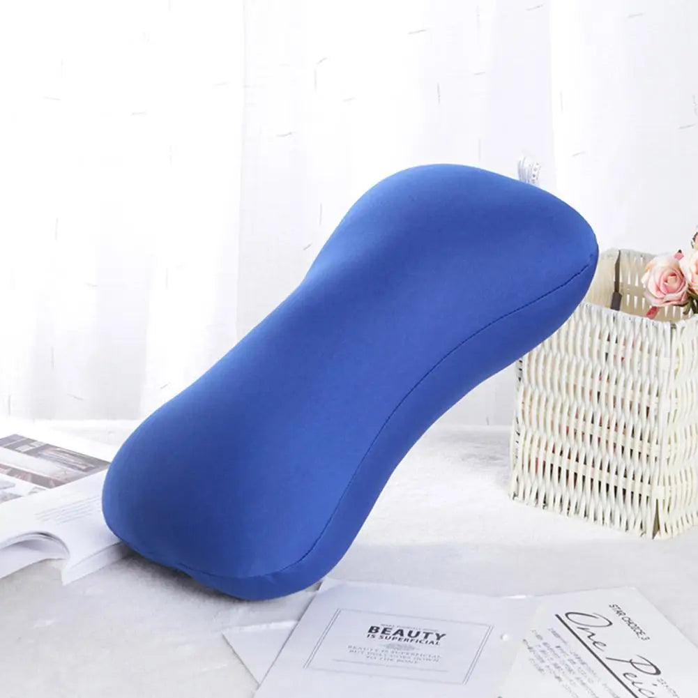 A blue microbead neck pillow resting on a white surface next to a woven basket and some papers.