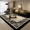 A black and white geometric area rug featuring intricate patterns in a modern living room setting.