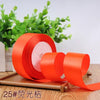 Roll of bright orange satin ribbon for gift wrapping and DIY crafts
