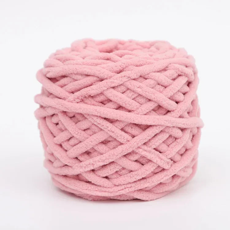 A ball of pink chenille knitting yarn used for hand crafting.