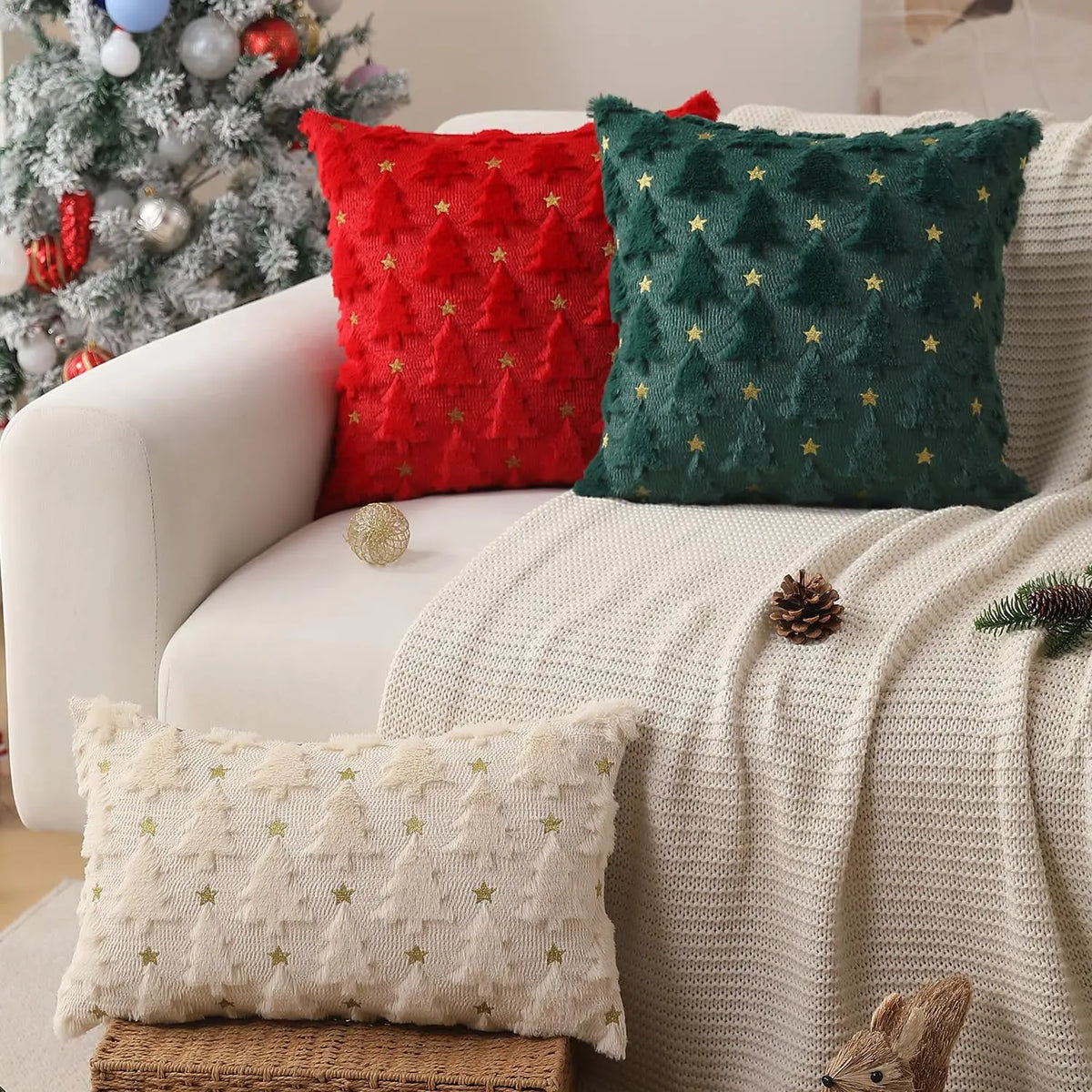 A collection of festive knitted cushion covers in red, green, and cream textures displayed on a sofa.