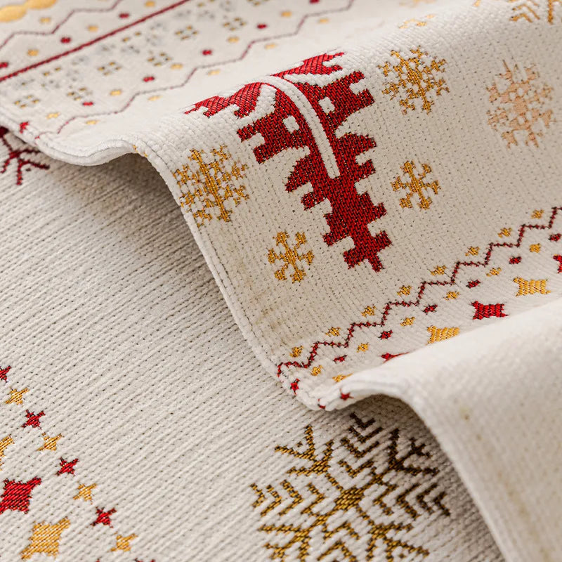 Close-up of a cream fabric with red and gold Nordic patterns, showing a decorative trim detail.