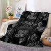 A black fleece throw blanket featuring portraits of Stray Kids members and the group's name in white text.