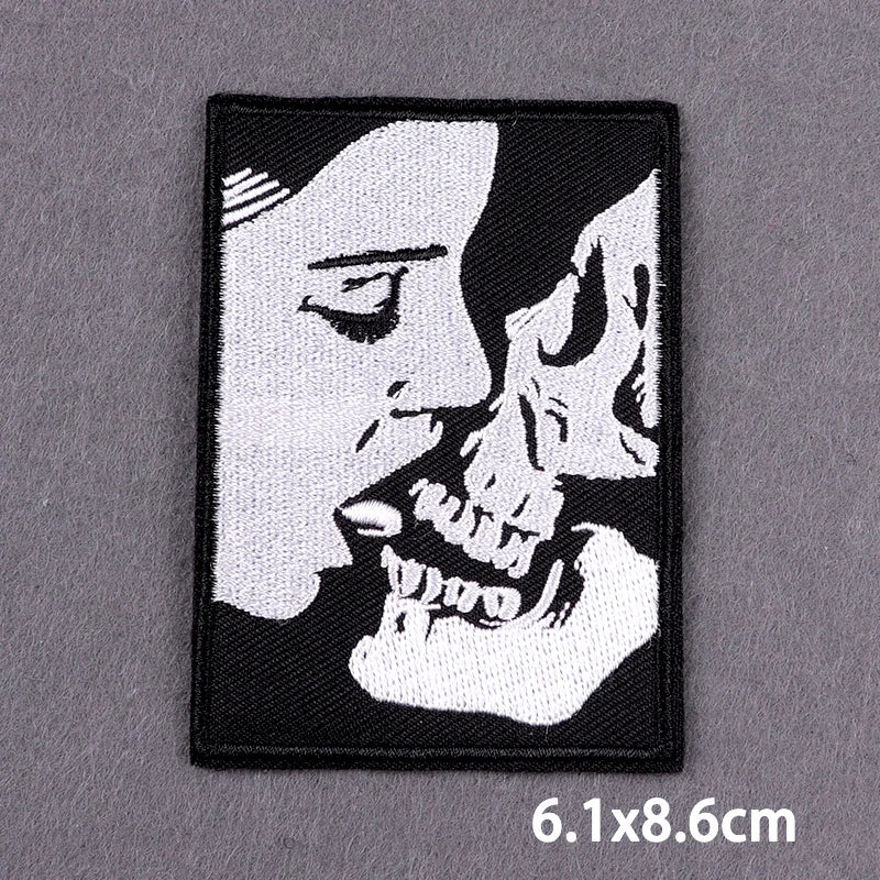 Black and white embroidered patch featuring a profile of a human face and a skull.