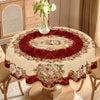 Elegant floral tablecloth with a vintage rose print on a deep red fabric displayed on a wooden table.