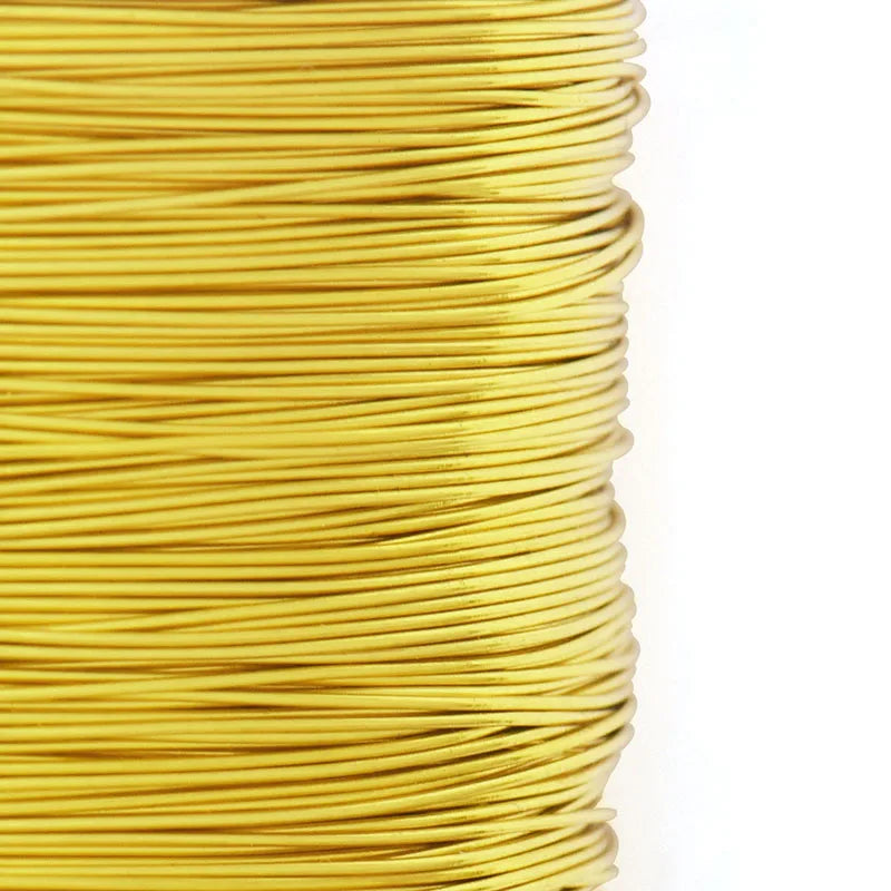 A spool of thin, bright yellow copper-clad steel wire coiled tightly.