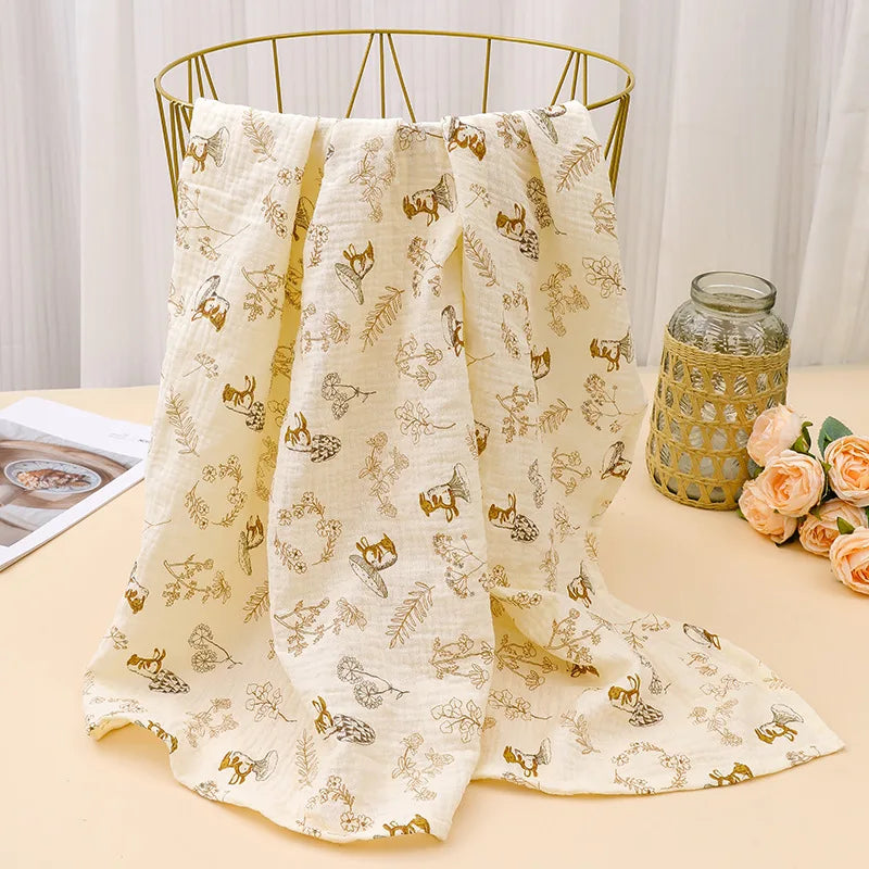 Cream patterned printable cotton crib sheets draped over a gold wire hanger.