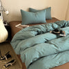 A teal striped duvet cover set with matching pillows on a bed.