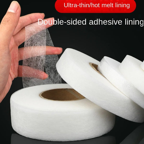 A hand is applying ultra-thin hot melt lining double-sided adhesive tape to a roll of white fabric tape.