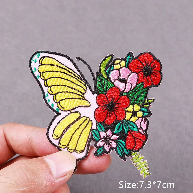 Embroidered butterfly patch featuring yellow and white wings surrounded by red and pink floral embroidery